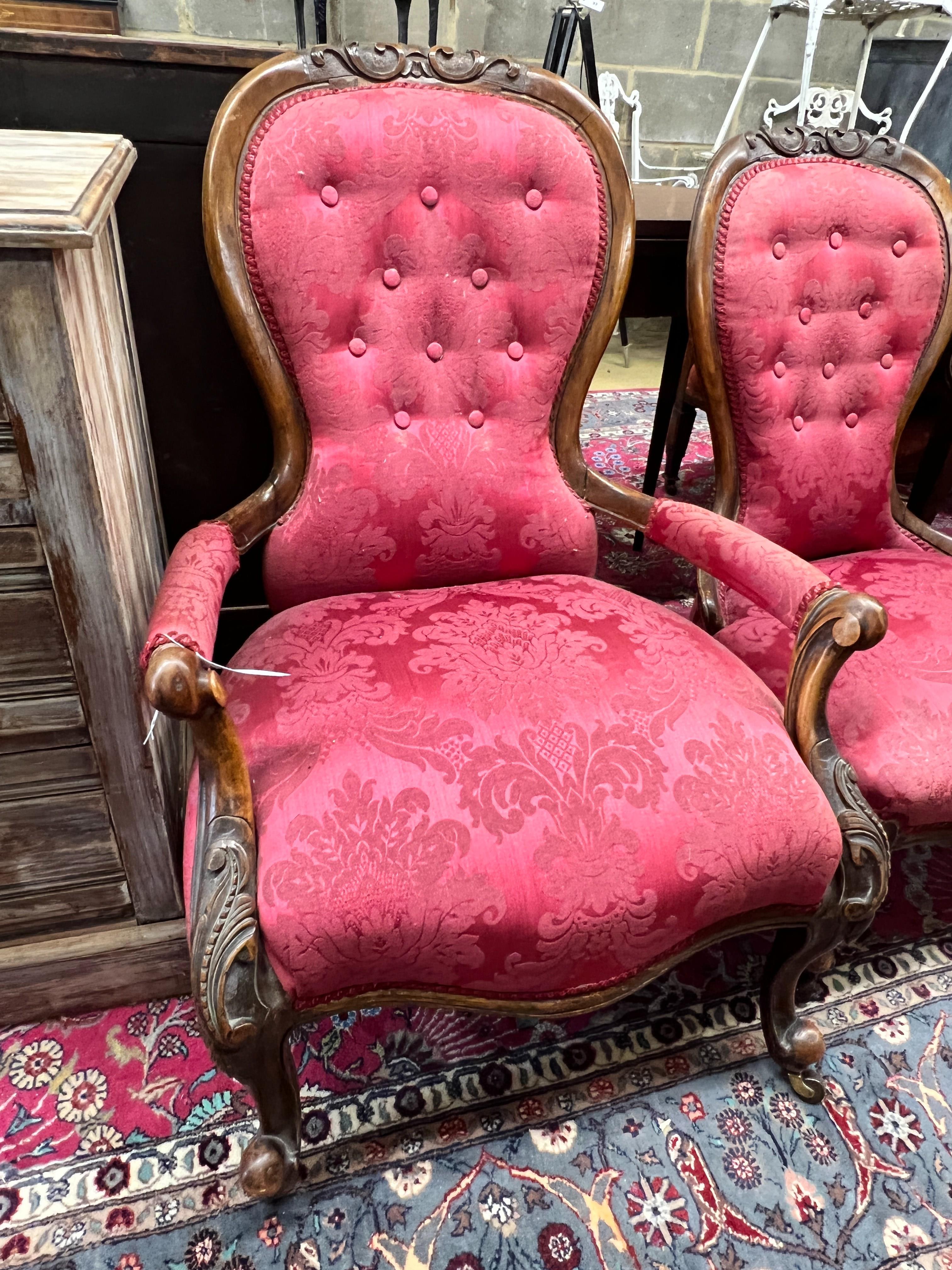 A pair of Victorian walnut spoon back upholstered chairs, one with arms